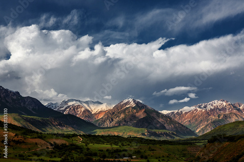 Beautiful clouds against the background of mountains and green trees. Mountain landscape of the highlands.