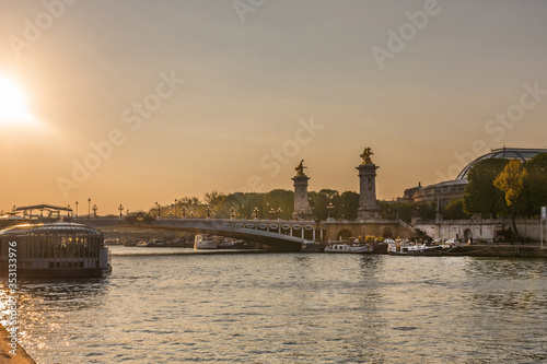 sunset over seine river in Paris with Grand Palais and Pont Alexandre III bridge in the background 