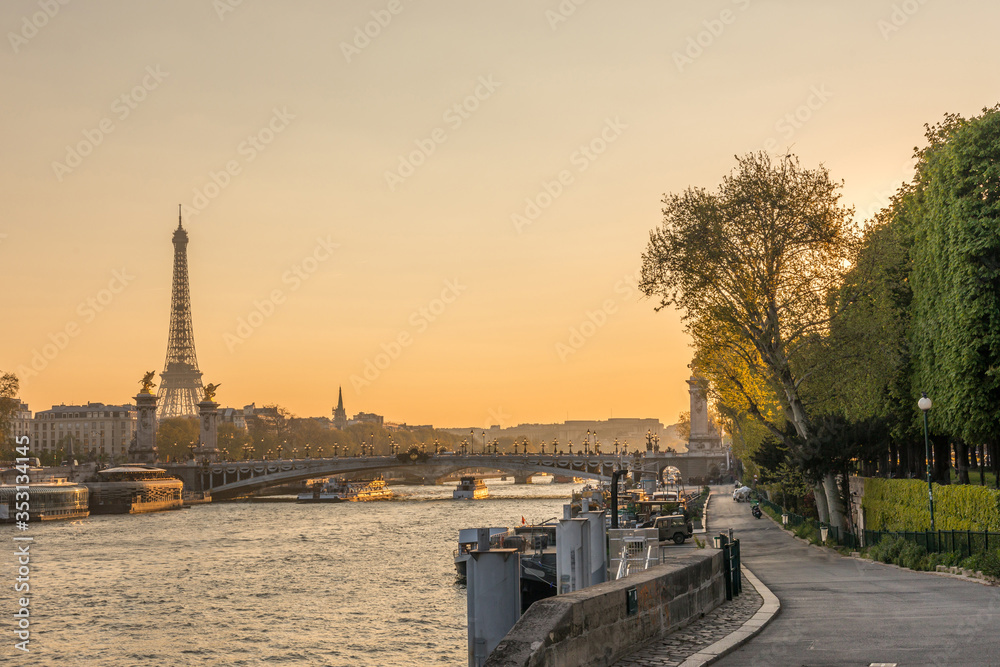 sunset over Seine river in Paris with Eiffel tower and Pont Alexandre III bridge in the background