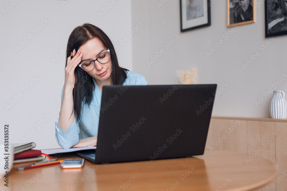 Frustrated business woman worried about problem sitting with laptop