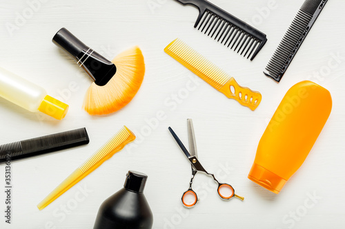 Hairdresser tools, hair salon equipment for professional hairdressing in beauty salon, haircut service. Top view flat lay on white background.Hairbrush, comb, scissors, shampo. Orange black set