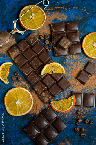 a slice of dark chocolate in cocoa powder with dried oranges