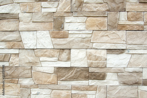 The structure of the beige wall of a beautiful ancient building. Abstract background of decorative brick wall. Copyspace
