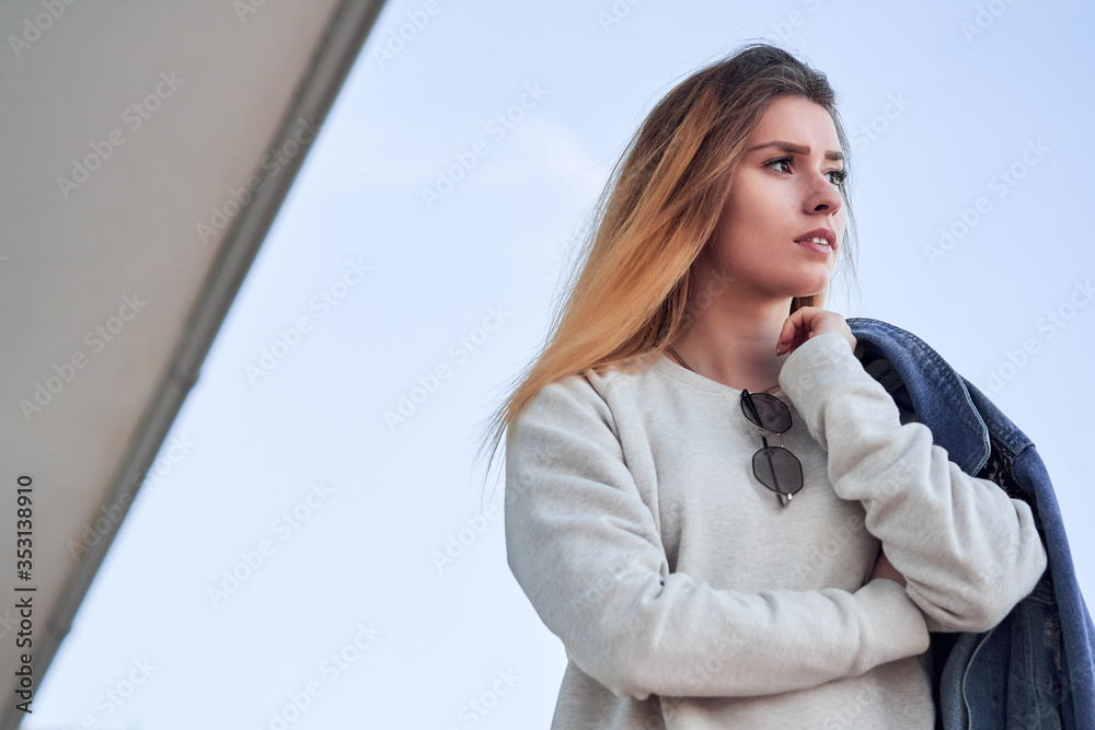 beautiful charismatic girl in a light sweatshirt v denim jacket with long blonde hair on a summer day beautiful charismatic girl in a light sweatshirt v denim jacket with long blonde hair on a summer day