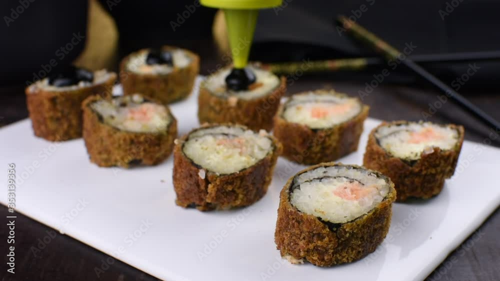 Pouring tare sauce in salmon fish hot rolls Pouring tare sauce in salmon fish hot rolls