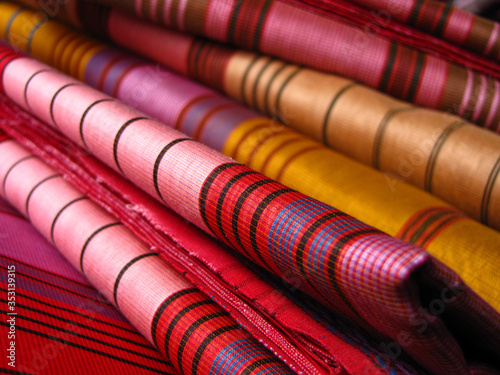 Billede på lærred Pink and yellow colored sarees stacked together