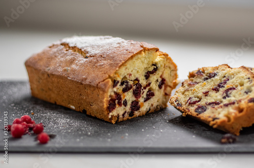 Orange pound cake with cranberries on a black stone plate