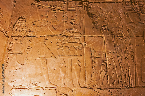 Hieroglyphic carvings on an ancient egyptian temple wall at night