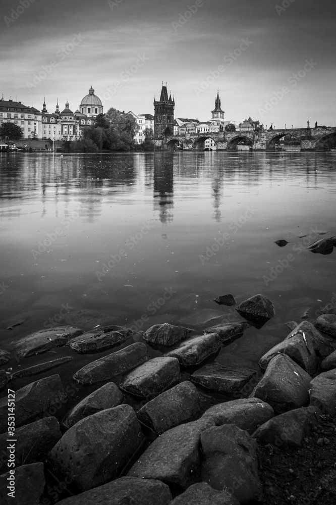 Prague skyline and bridge over river in black and white. Czech Republic.