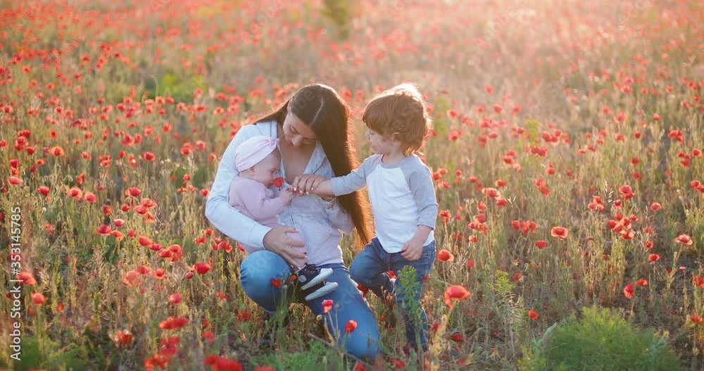 Mom with two children in poppy field enjoy nature. Mom with two children in poppy field enjoy nature.
