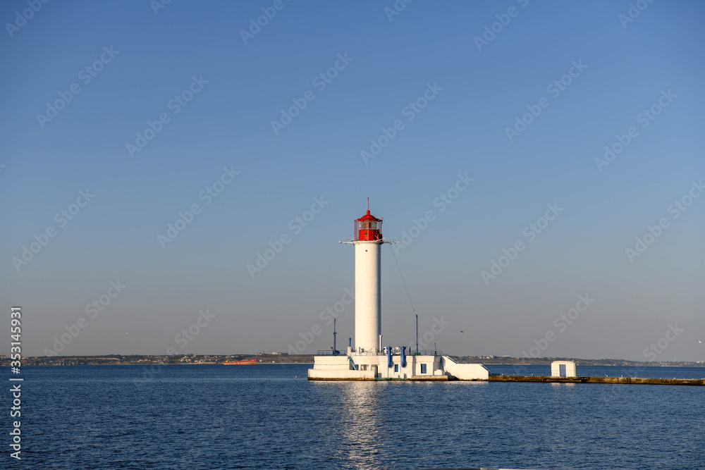 The lighthouse of the port of Odessa illuminated by the setting sun.