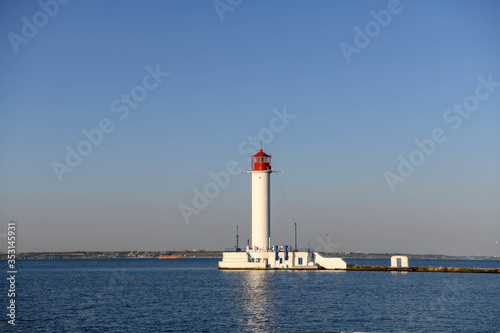 The lighthouse of the port of Odessa illuminated by the setting sun.