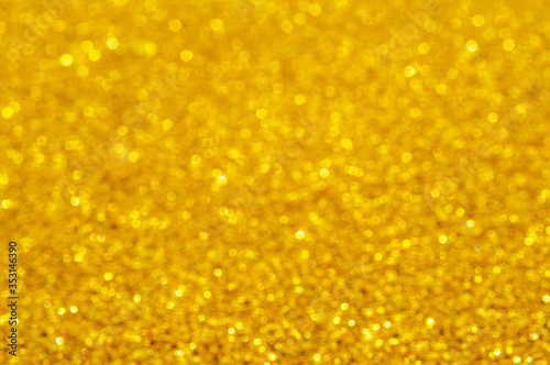 Golden defocused glitter background with copy space. Christmas background. Golden holiday glowing abstract background. Blurred bokeh