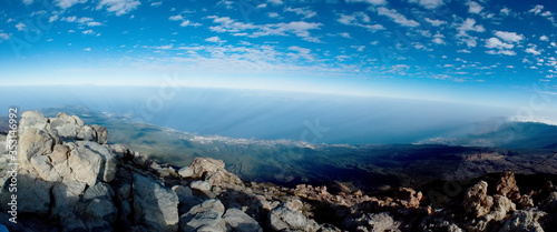 View from the top of a volcano Teide to the island of Tenerife. Cloud shadows are visible on the ground. The sun's rays pierce the air.
