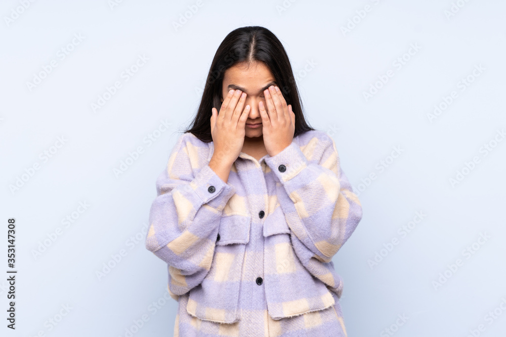 Young Indian woman isolated on blue background with tired and sick expression Young Indian woman isolated on blue background with tired and sick expression