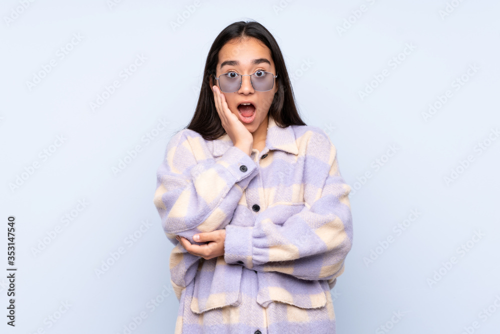 Young Indian woman isolated on blue background surprised and shocked while looking right Young Indian woman isolated on blue background surprised and shocked while looking right