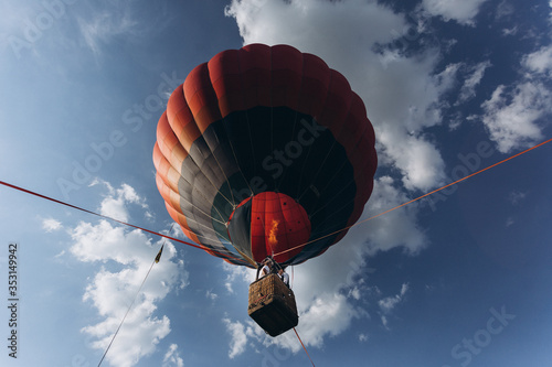 a balloon rising in blue sky above the forest