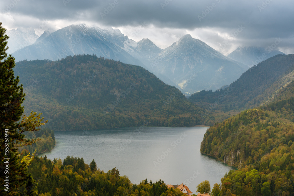 Aerial view of Schwansee lake secluded between green mountains