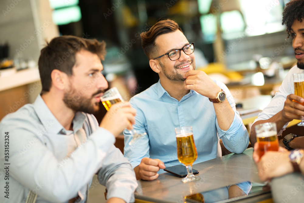 conversation of young businessmen while sitting in a cafe and drinking cold wheat beer