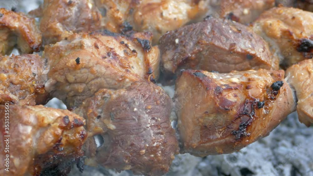 Barbecue is fried on the grill. Pork meat on skewers. Juicy slices of meat on fire. Cooking on a picnic in nature. Barbecue is fried on the grill. Pork meat on skewers. Juicy slices of meat on fire. Cooking on a picnic in nature.