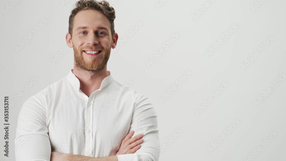 Handsome young cheery happy man in white shirt isolated over white wall background