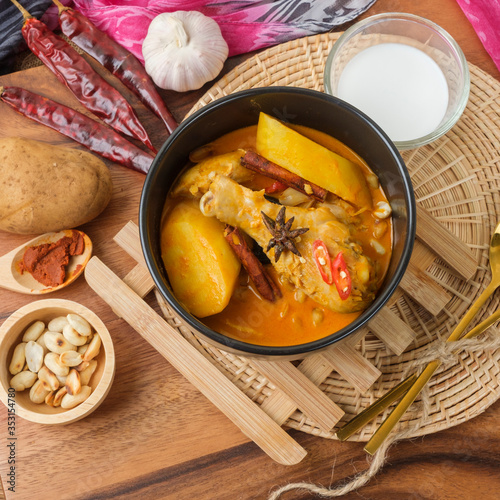 Massaman Curry With Chicken and Thai herbs with wood background texture