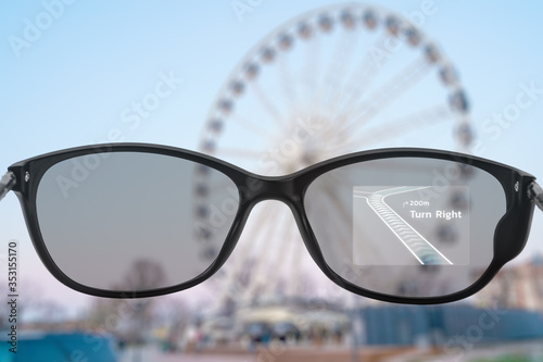 Fototapeta Naklejka Na Ścianę i Meble -  Smart glasses with maps and ferris wheel in the background