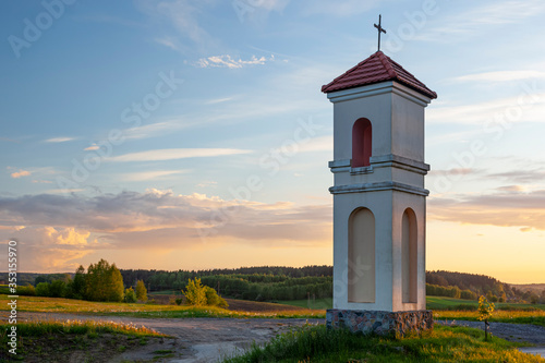 Kapliczka polna w Gietrzwałdzie - wieś na Warmii i mazurach, Polska - krajobraz wiosenny, zachód słońca.