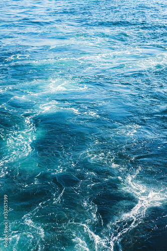 Fototapeta Naklejka Na Ścianę i Meble -  Sea or ocean waves surface texture. Abstract summer blue water background with splashes of sea foam.