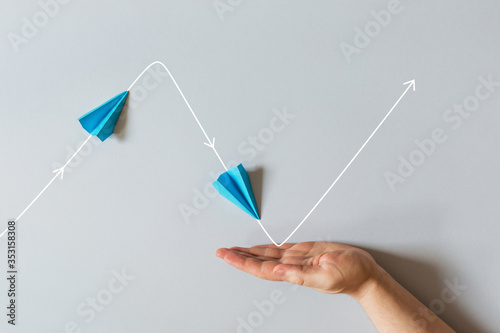 concept of small business support. graph of of economic crisis, stagnation and recovery with help of state. paper plane flies up, falls down photo