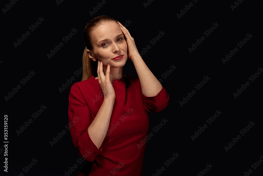 Bright beautiful young woman holds her hands in her face and poses Bright beautiful young woman holds her hands in her face and poses