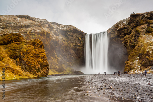 Fototapeta Naklejka Na Ścianę i Meble -  Skogafoss waterfall in South Iceland. Tourists admiring the waterfall. Popular and famous tourist attraction.