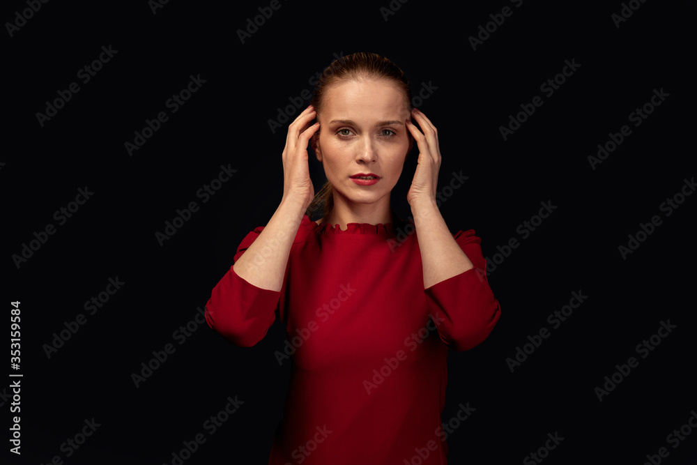 Terrified young blonde woman looks at the camera.