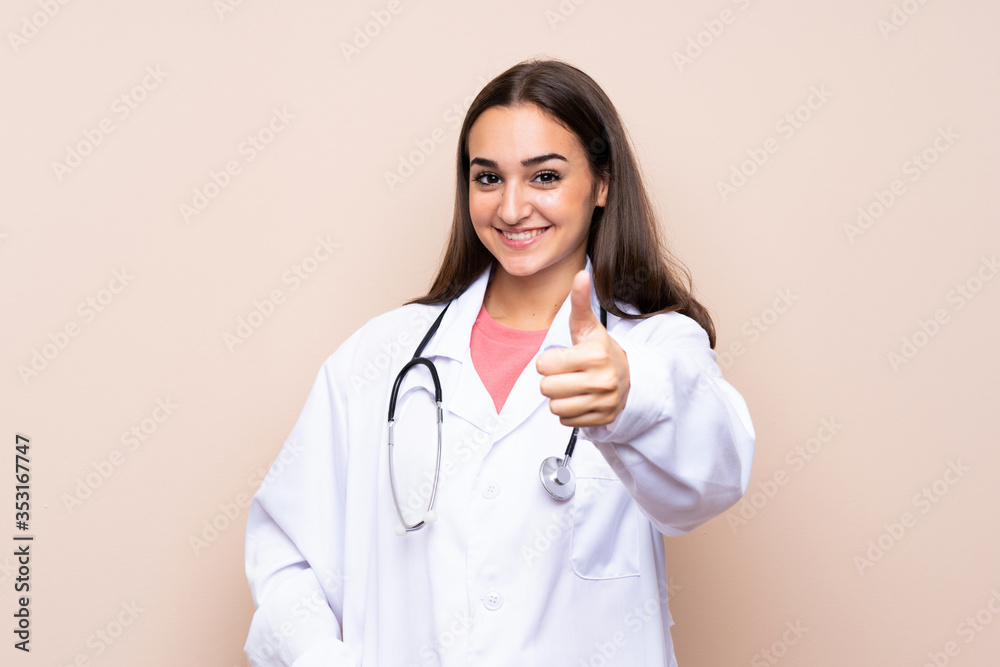 Young woman over isolated background with doctor gown and with thumb up Young woman over isolated background with doctor gown and with thumb up