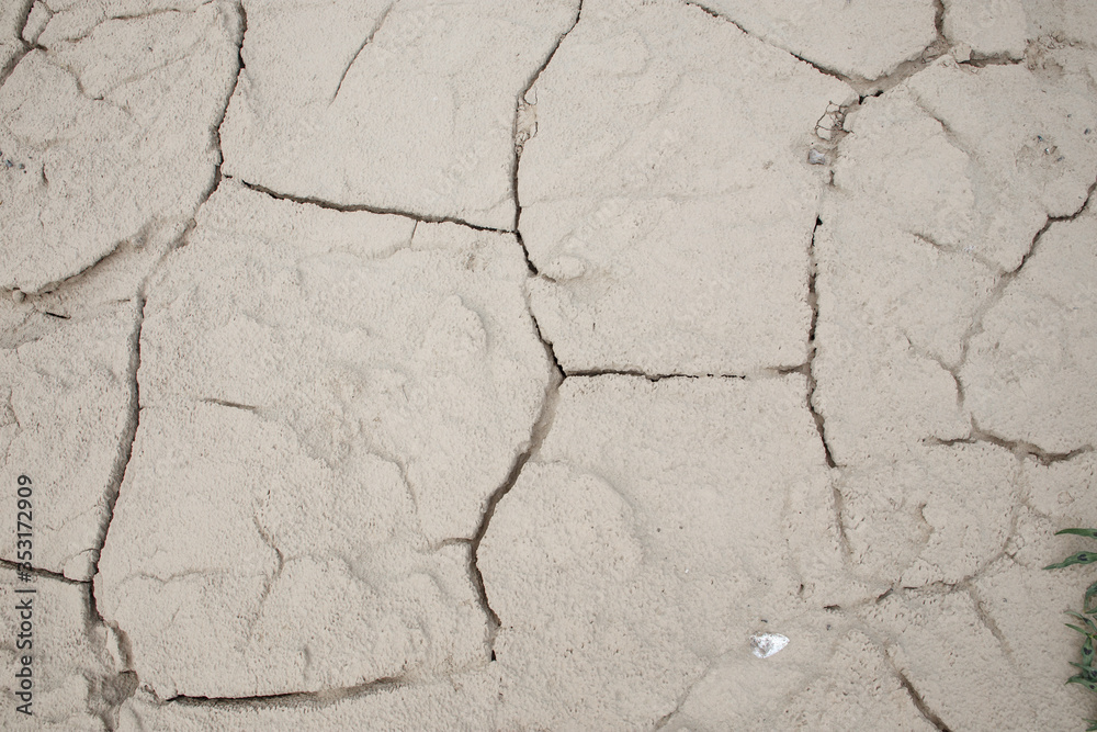 Obraz premium Cracked earth soil ground texture background. Mosaic pattern of dried mud clay earth and sand, top view. The concept of soil erosion climate change and sudden changes in air temperature.