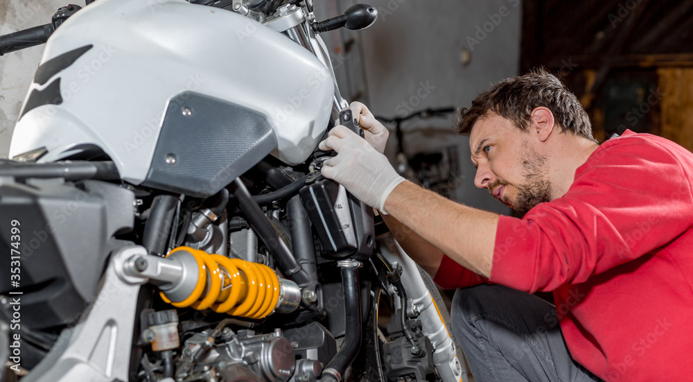 Mechanic repairman doing maintenance or repairing, fixing on the motorcycle, motorbike, service center Mechanic repairman doing maintenance or repairing, fixing on the motorcycle, motorbike, service center