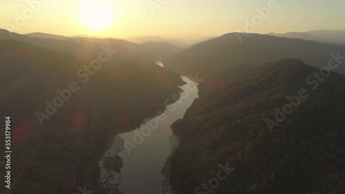 Aerial shot of beautiful mountains with river during sunset, drone flying forward against sky - Mekong River, Laos photo