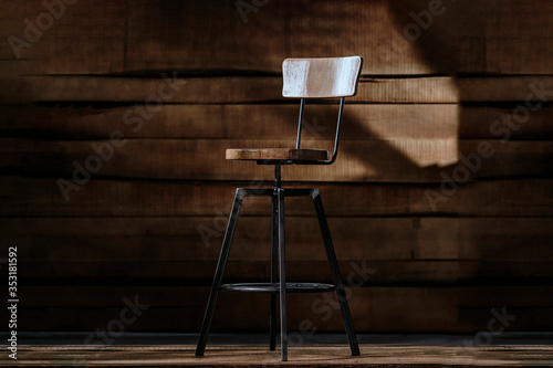 Industrial style bar height stool on a wooden background