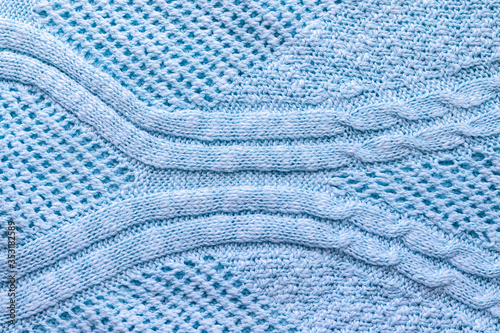 Bright blue knitted fabric texture. Rough sweater pattern background. Closeup view