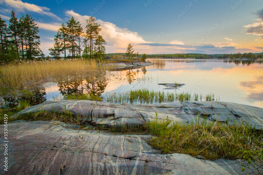Russia. Ladoga. Karelia. The delightful nature of Karelia. Landscapes of northern nature. Summer morning in Karelia. Reflection of taiga in the water. The coast of Lake Ladoga. Untouched nature.