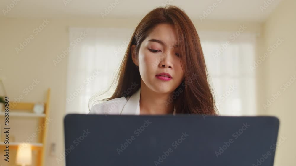 Portrait of freelance Asia women casual wear using laptop working in living room at home. Working from home, remotely work, self isolation, social distancing, quarantine for coronavirus prevention. Portrait of freelance Asia women casual wear using laptop working in living room at home. Working from home, remotely work, self isolation, social distancing, quarantine for coronavirus prevention.