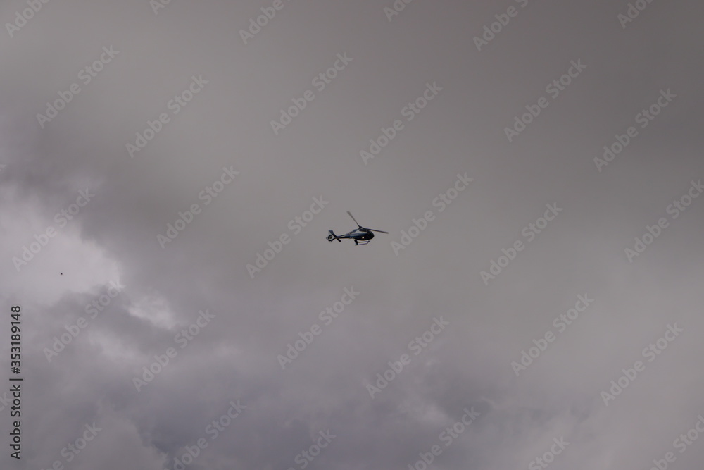 helicopter flying in the cloudy sky