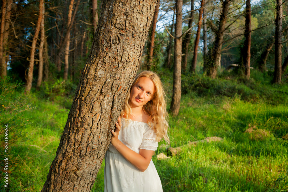 Blonde girl in white dress, in a pine forest, Croatia Blonde girl in white dress, in a pine forest, Croatia