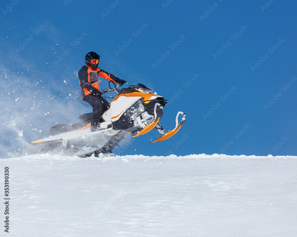 Snowmobile Jump. Extreme Snowmobile Ride & Racing. a bright suit and a snow motorcycle. Winter Recreation. high resolution and photo quality