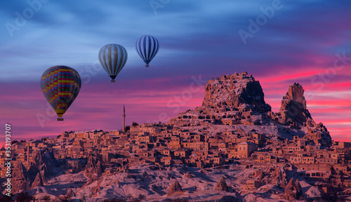 Hot air balloon flying over spectacular Cappadocia at red sunset