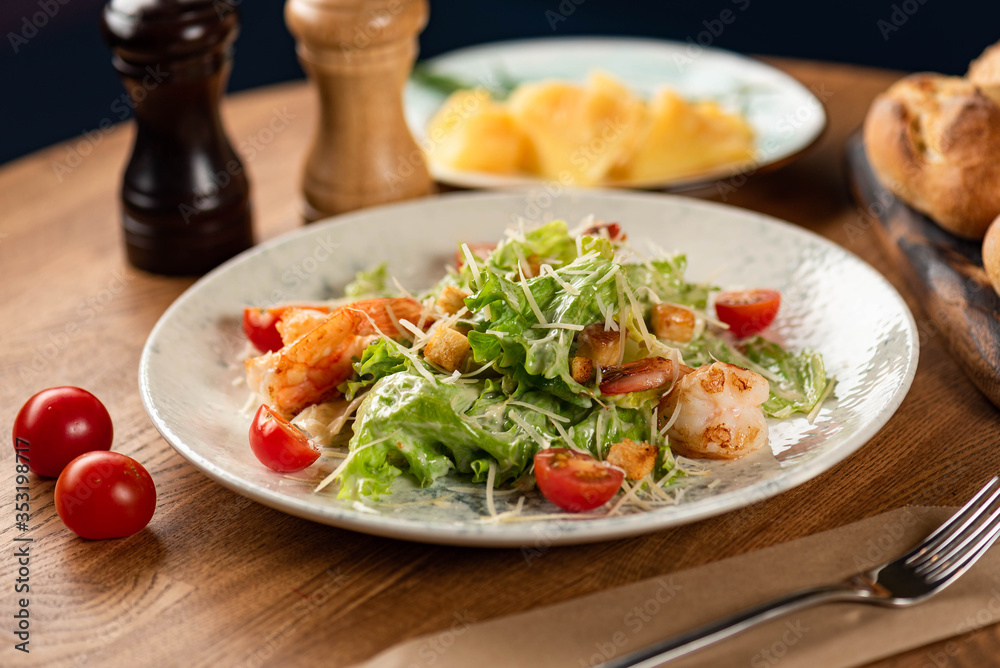 Caesar salad with prawns on a wooden table. Caesar salad with prawns on a wooden table.