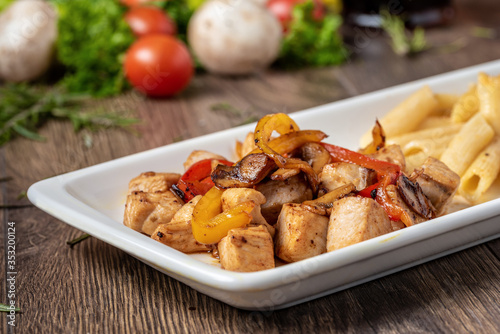 Photography grilled cubed chicken with pasta and salad