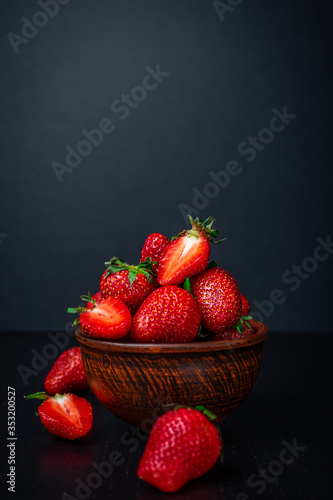 Bowl of strawberries on concrete dark background 