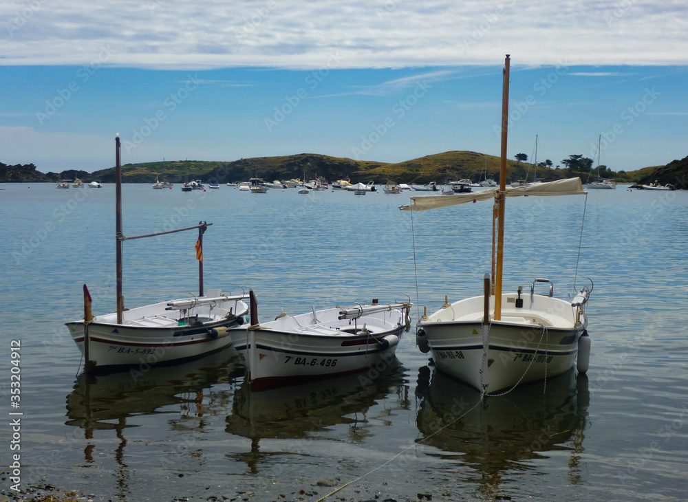 Three boats in the bay with shadows and refelctions in water