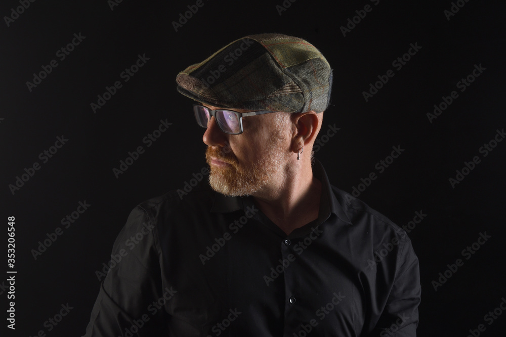 portrait of a man in low key,looking side clothing with cap and eyewear portrait of a man in low key,looking side clothing with cap and eyewear